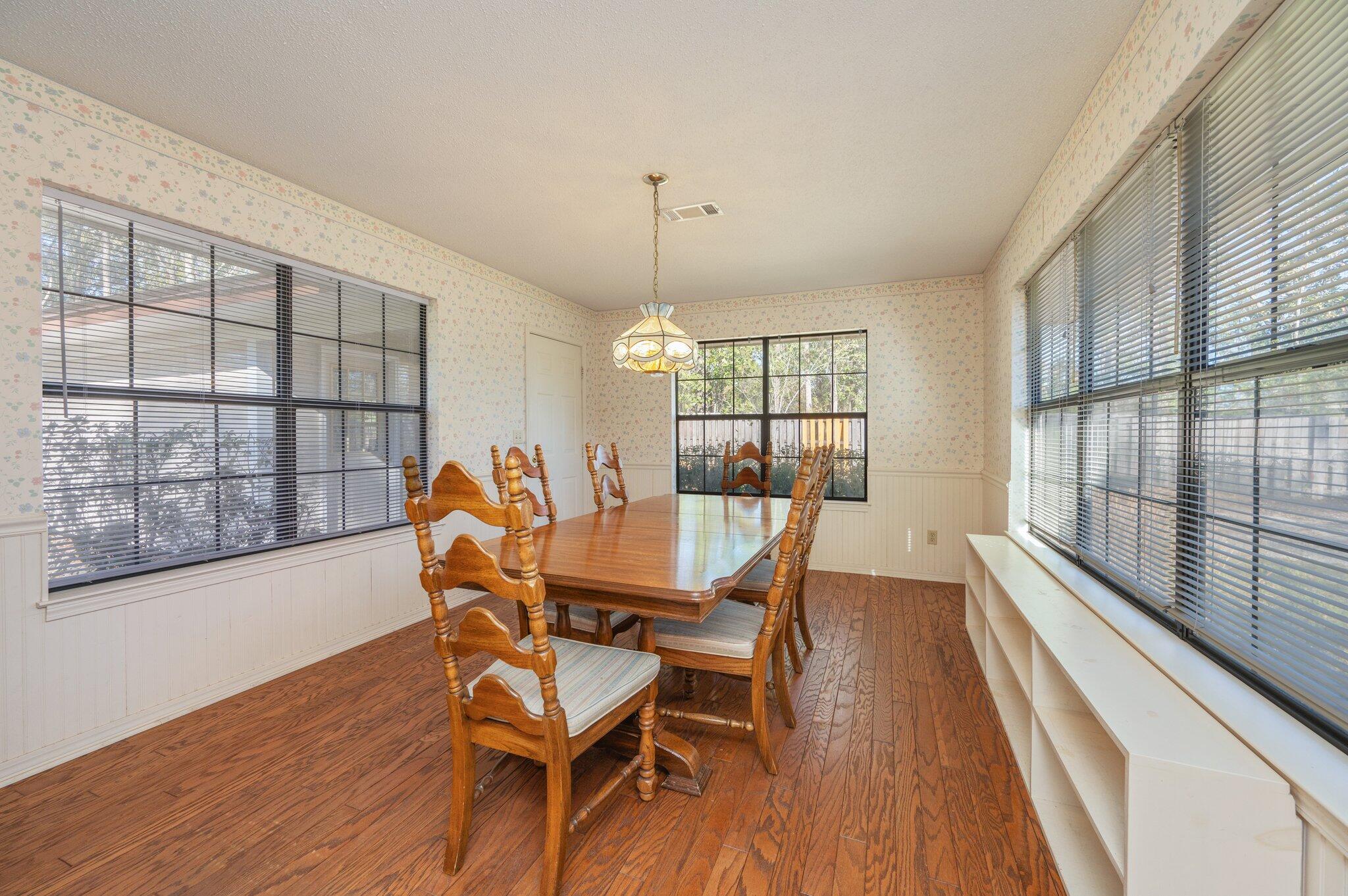 5836 Dairy Road Baker, FL 32531 - Photo 26 of 65 a dining room with furniture a chandelier and wooden floor