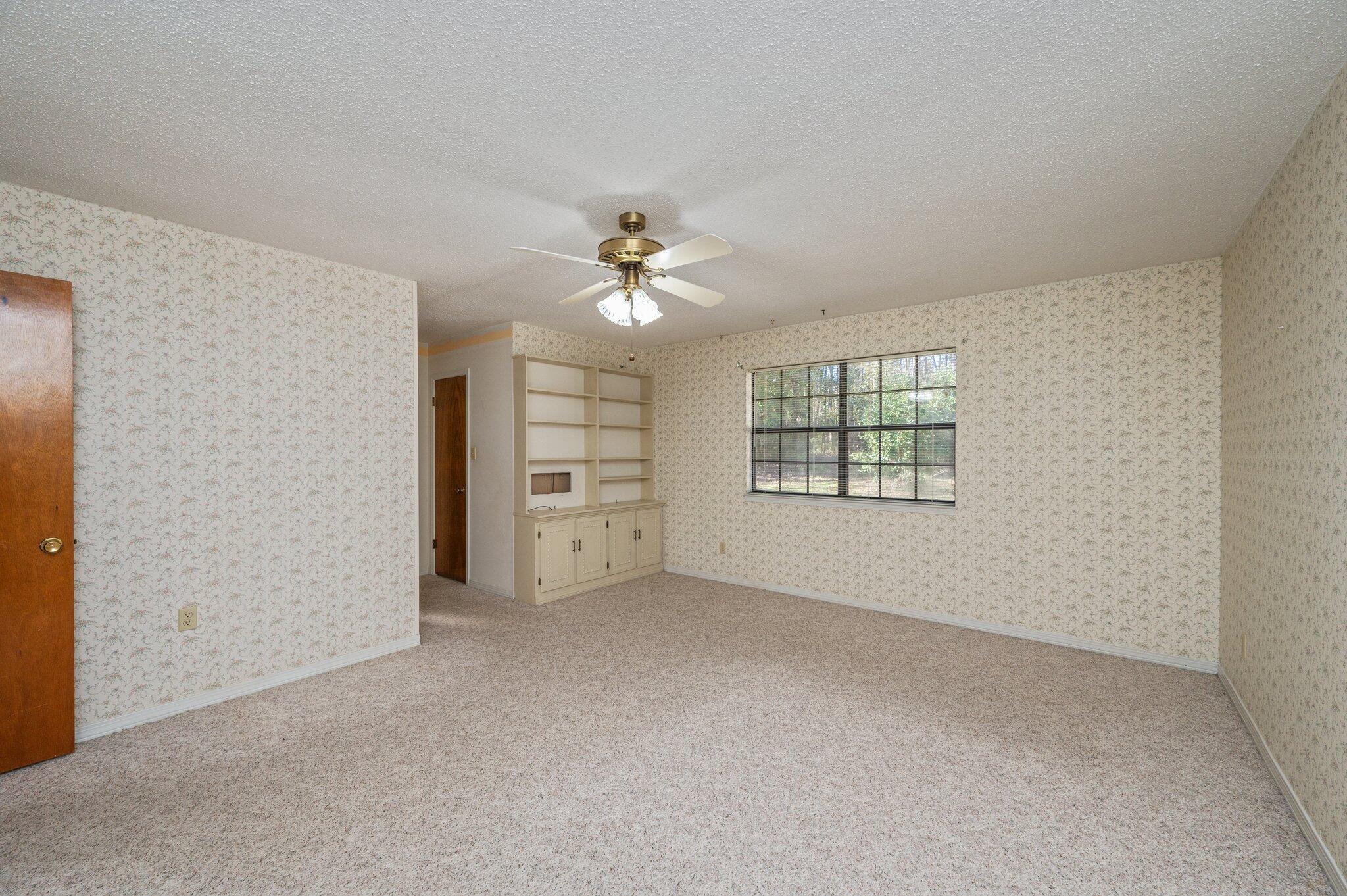 5836 Dairy Road Baker, FL 32531 - Photo 45 of 65 an empty room with windows and chandelier fan