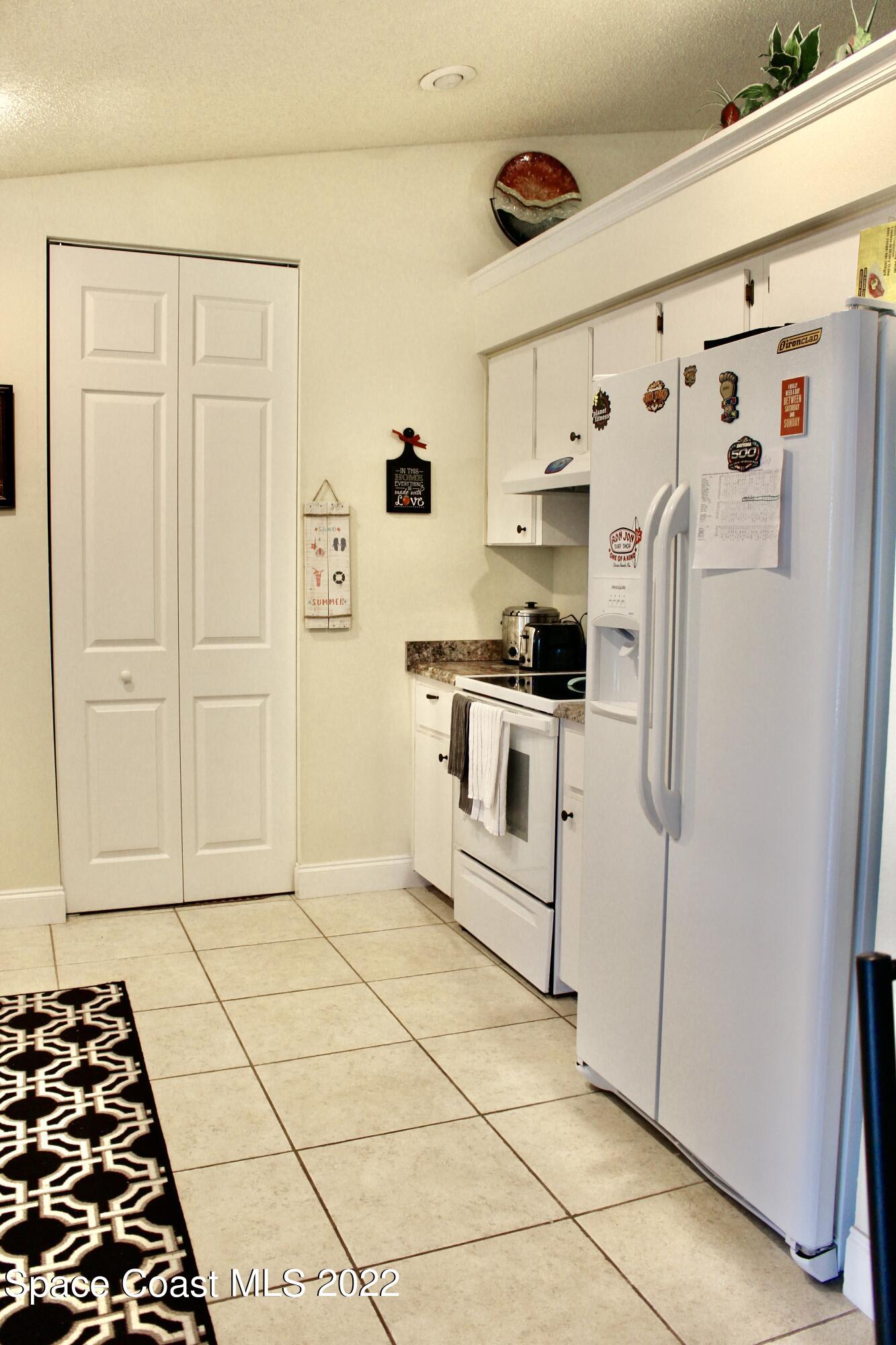 6737 Cecil Road Cocoa, FL 32927 - Photo 11 of 39 a kitchen with white cabinets and white appliances