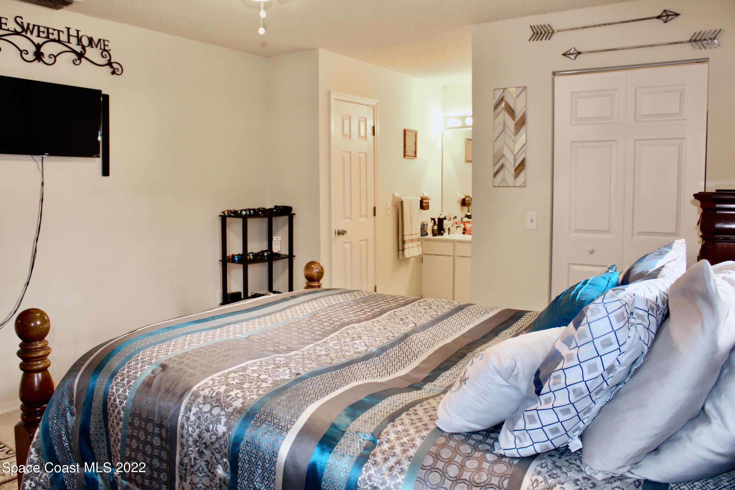 6737 Cecil Road Cocoa, FL 32927 - Photo 24 of 39 a bedroom with a bed and flat screen tv