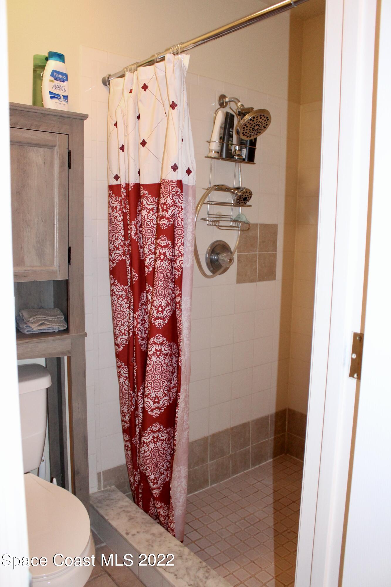 6737 Cecil Road Cocoa, FL 32927 - Photo 27 of 39 a bathroom with a toilet and a shower curtain