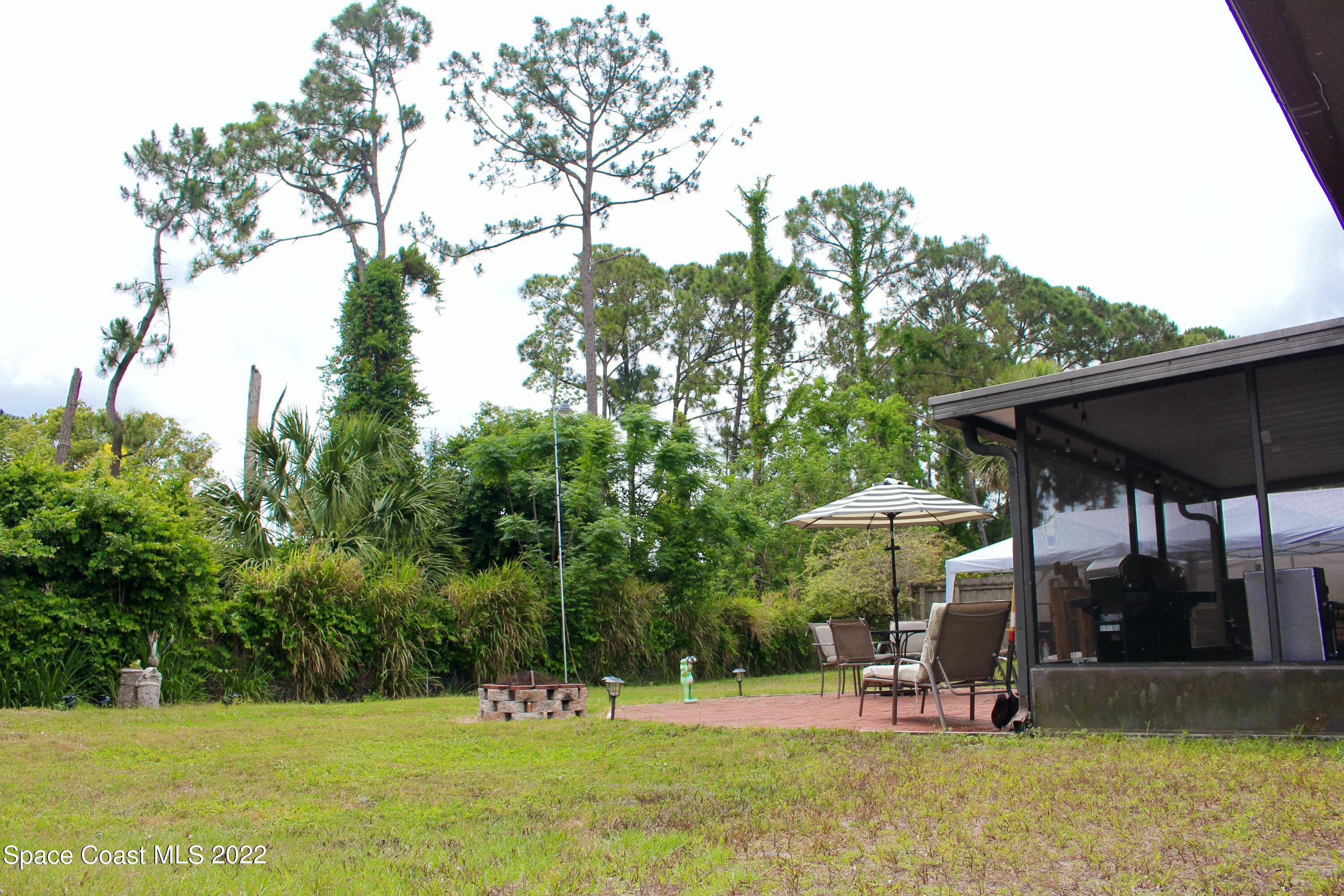 6737 Cecil Road Cocoa, FL 32927 - Photo 34 of 39 a view of a swimming pool with a table and chairs under an umbrella