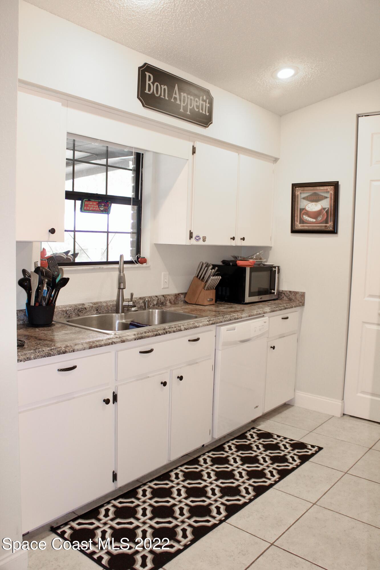 6737 Cecil Road Cocoa, FL 32927 - Photo 8 of 39 a kitchen with a stove and white cabinets