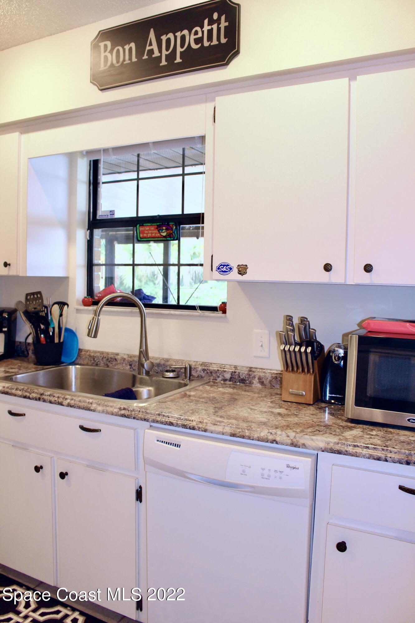 6737 Cecil Road Cocoa, FL 32927 - Photo 9 of 39 a kitchen with sink cabinets and window