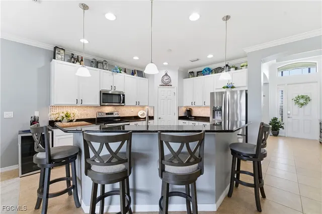 a kitchen with stainless steel appliances kitchen island a chandelier and refrigerator