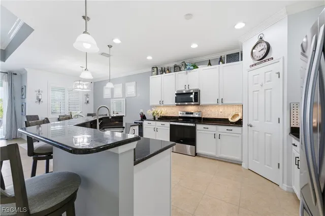 a kitchen with stainless steel appliances granite countertop a sink refrigerator and cabinets
