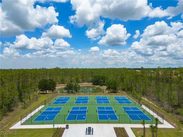 a view of swimming pool with seating area and trees in the background