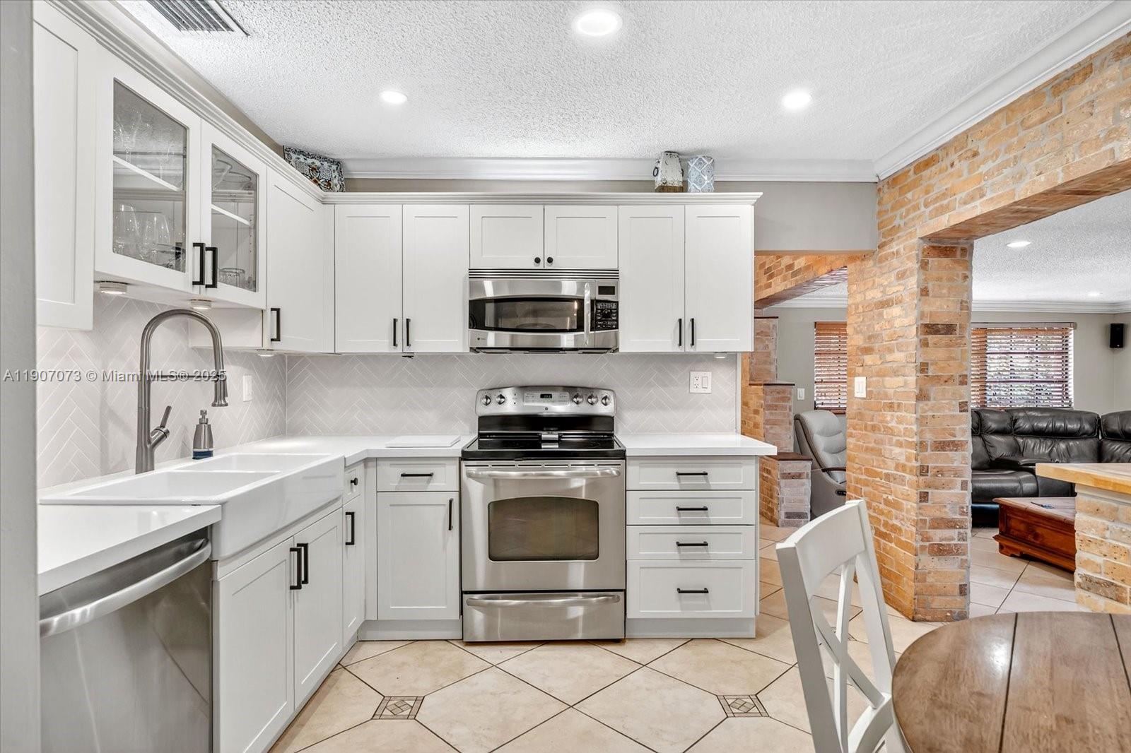 1300 West 77th Street Hialeah, FL 33014 - Photo 13 of 41 a kitchen with stainless steel appliances granite countertop a stove sink and cabinets