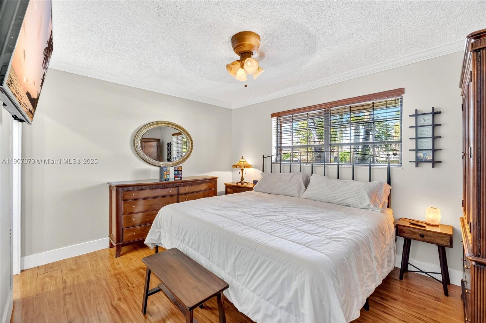 1300 West 77th Street Hialeah, FL 33014 - Photo 16 of 41 a bedroom with a bed a window and a chandelier