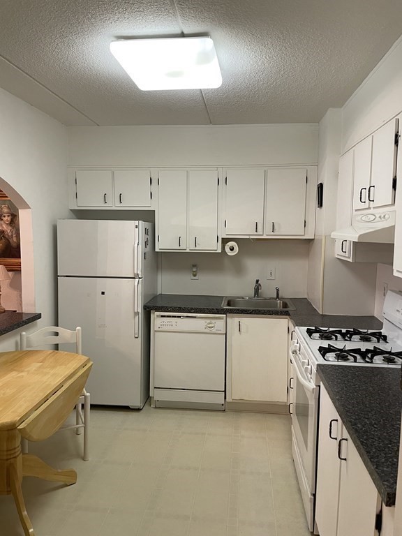 1550 Worcester Road, Unit 114 Framingham, MA 01702 - Photo 7 of 21 a kitchen with a refrigerator a stove a sink and white cabinets