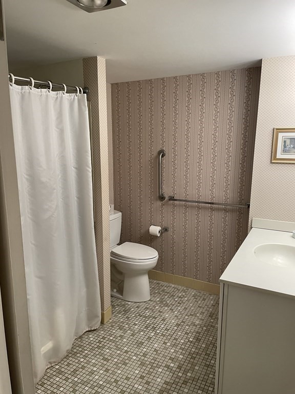 1550 Worcester Road, Unit 114 Framingham, MA 01702 - Photo 10 of 21 a bathroom with a toilet and a shower curtain