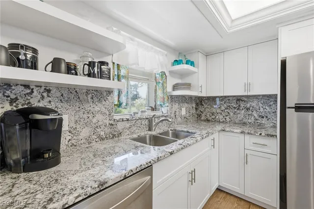 a kitchen with granite countertop a sink a stove and cabinets