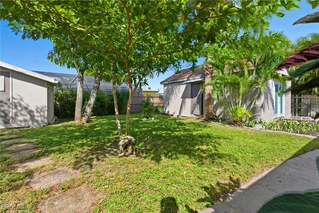 a backyard of a house with plants and tree