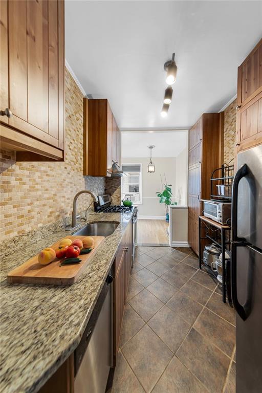9281 Shore Road, Unit 608 Brooklyn, NY 11209 - Photo 4 of 13 a kitchen with granite countertop a sink a stove and cabinets