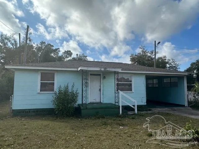 a view of a house with backyard and a tree