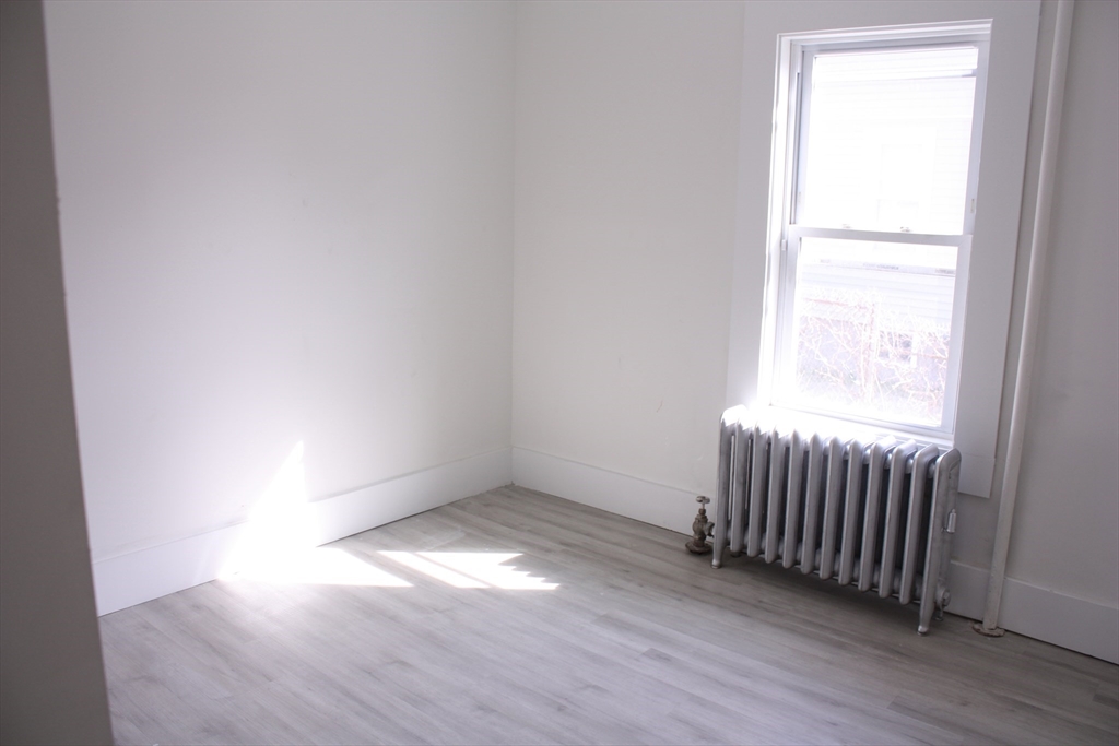 23 Foster Street Springfield, MA 01105 - Photo 7 of 15 an empty room with wooden floor and windows