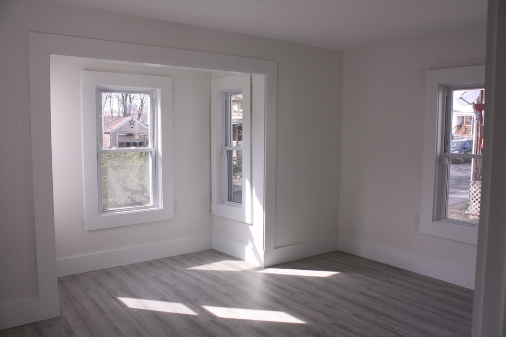 23 Foster Street Springfield, MA 01105 - Photo 8 of 15 an empty room with wooden floor and windows