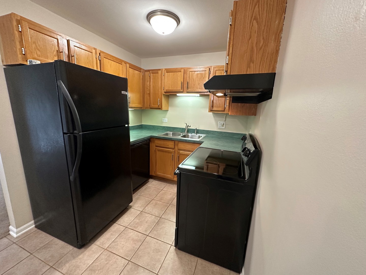 2100 Light Road, Unit 108 Oswego, IL 60543 - Photo 7 of 12 a kitchen with stainless steel appliances granite countertop a refrigerator and a sink