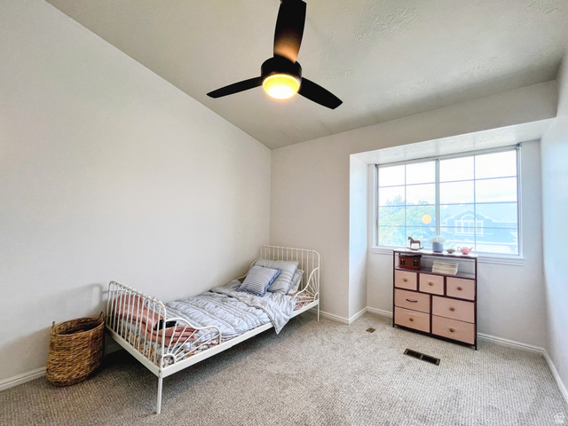 12169 Hidden Valley Road, Unit 44 Sandy, UT 84092 - Photo 25 of 49 Carpeted room with a ceiling fan, white walls, and a large window