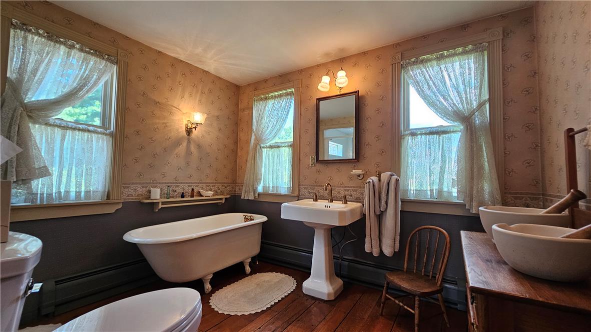 585 Buttermilk Road Hellertown, PA 18055 - Photo 35 of 82 Timeless elegance defines this primary bathroom, featuring rich hardwood flooring and classic wall sconces.