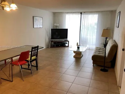 a living room with furniture a flat screen tv and a window