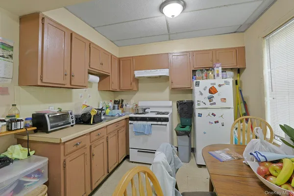 a kitchen with stainless steel appliances granite countertop a refrigerator sink and white cabinets