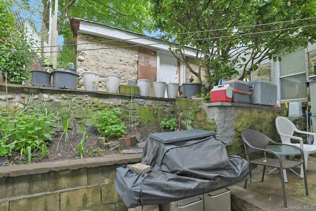 a view of backyard with outdoor seating and plants