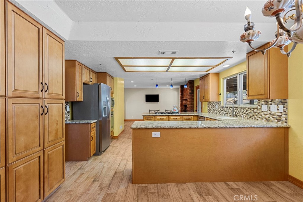 902 Searchlight Ranch Road Acton, CA 93510 - Photo 13 of 52 a kitchen with stainless steel appliances granite countertop a refrigerator a stove and a wooden floors
