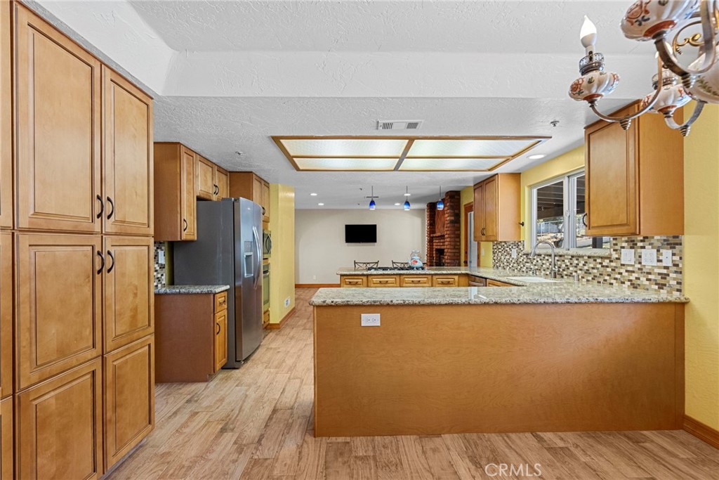 902 Searchlight Ranch Road Acton, CA 93510 - Photo 13 of 52 a kitchen with stainless steel appliances granite countertop a refrigerator a stove and a wooden floors