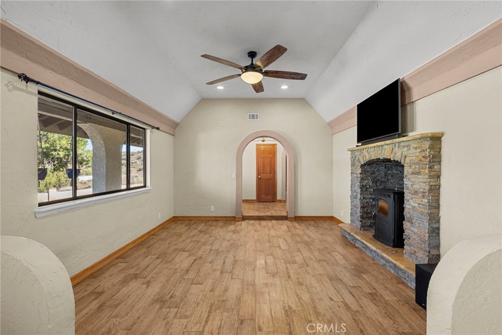 902 Searchlight Ranch Road Acton, CA 93510 - Photo 16 of 52 a view of an empty room with a fireplace and a window