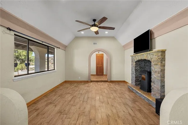 a view of an empty room with a fireplace and a window