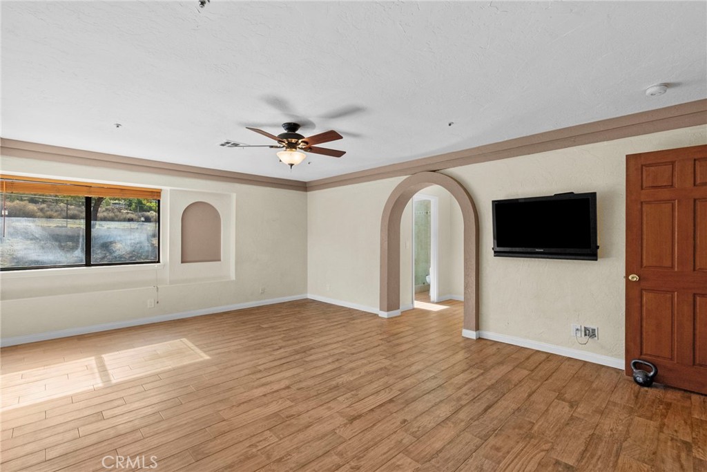902 Searchlight Ranch Road Acton, CA 93510 - Photo 27 of 52 a view of empty room with wooden floor and fan