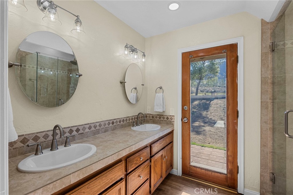 902 Searchlight Ranch Road Acton, CA 93510 - Photo 31 of 52 a bathroom with a granite countertop sink a mirror and shower