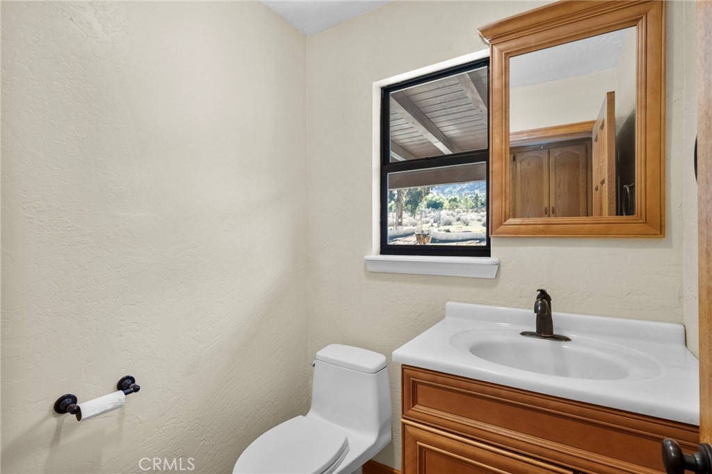 902 Searchlight Ranch Road Acton, CA 93510 - Photo 33 of 52 a bathroom with a toilet sink vanity and mirror