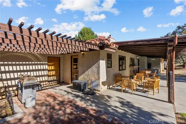 a view of a patio with table and chairs and wooden fence