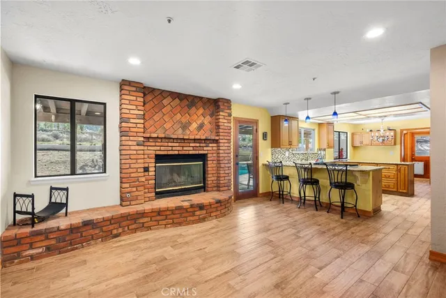 a living room with chairs flat screen tv and a fireplace
