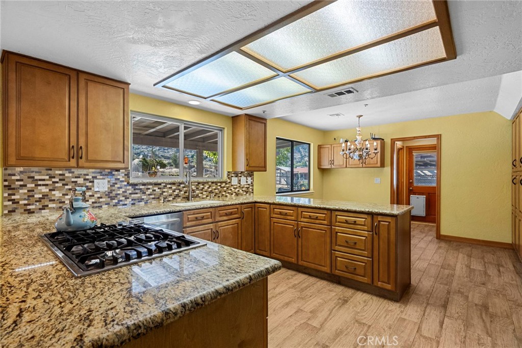 902 Searchlight Ranch Road Acton, CA 93510 - Photo 9 of 52 a kitchen with stainless steel appliances granite countertop a stove a sink dishwasher and cabinets with wooden floor