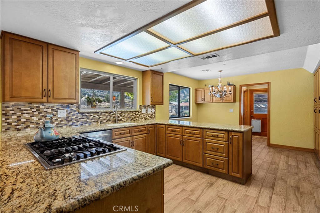 902 Searchlight Ranch Road Acton, CA 93510 - Photo 9 of 52 a kitchen with stainless steel appliances granite countertop a stove a sink dishwasher and cabinets with wooden floor