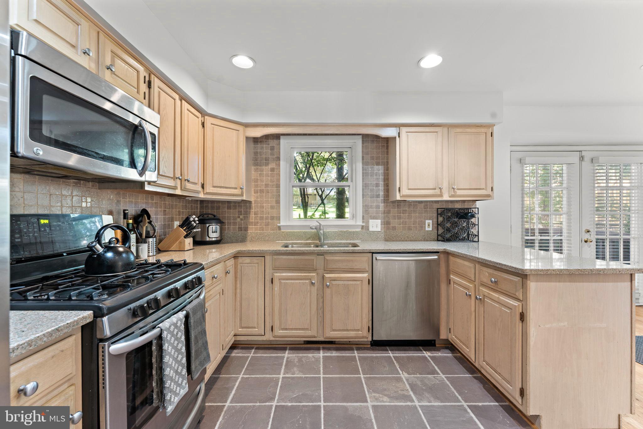 10934 Rocky Mt Way Silver Spring, MD 20902 - Photo 18 of 51 a kitchen with a stove a sink and a microwave