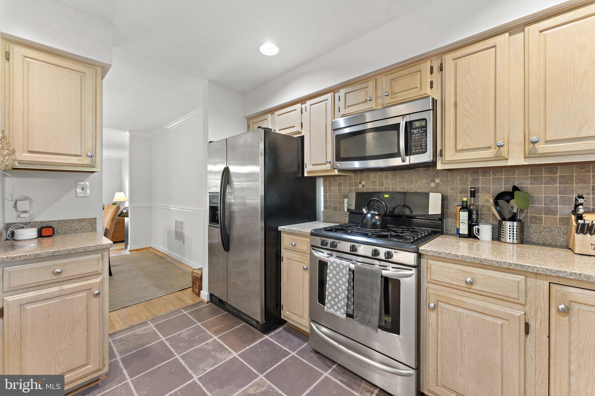 10934 Rocky Mt Way Silver Spring, MD 20902 - Photo 19 of 51 a kitchen with stainless steel appliances granite countertop a refrigerator a stove and white cabinets