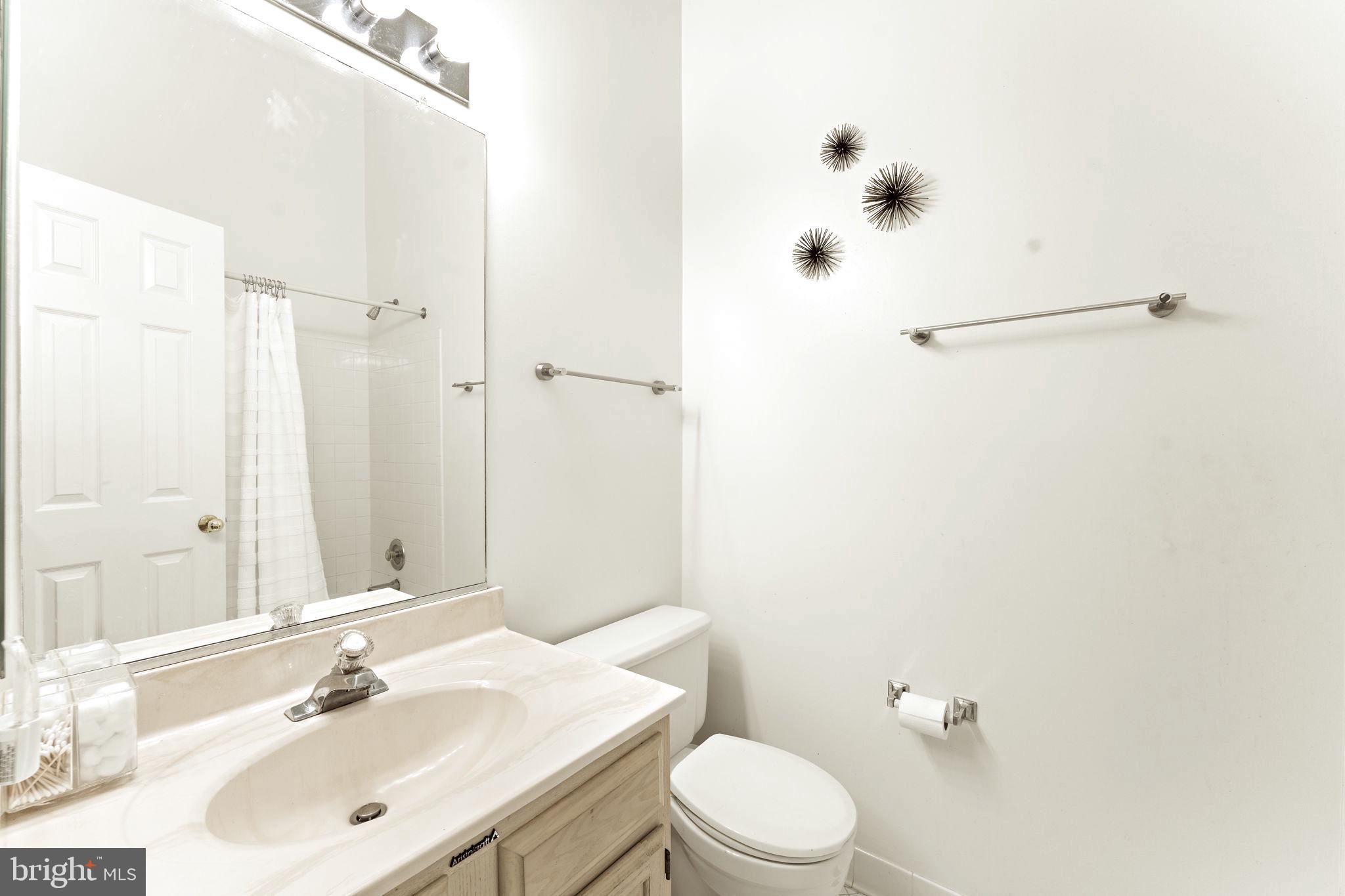 10934 Rocky Mt Way Silver Spring, MD 20902 - Photo 32 of 51 a bathroom with a sink mirror vanity and toilet