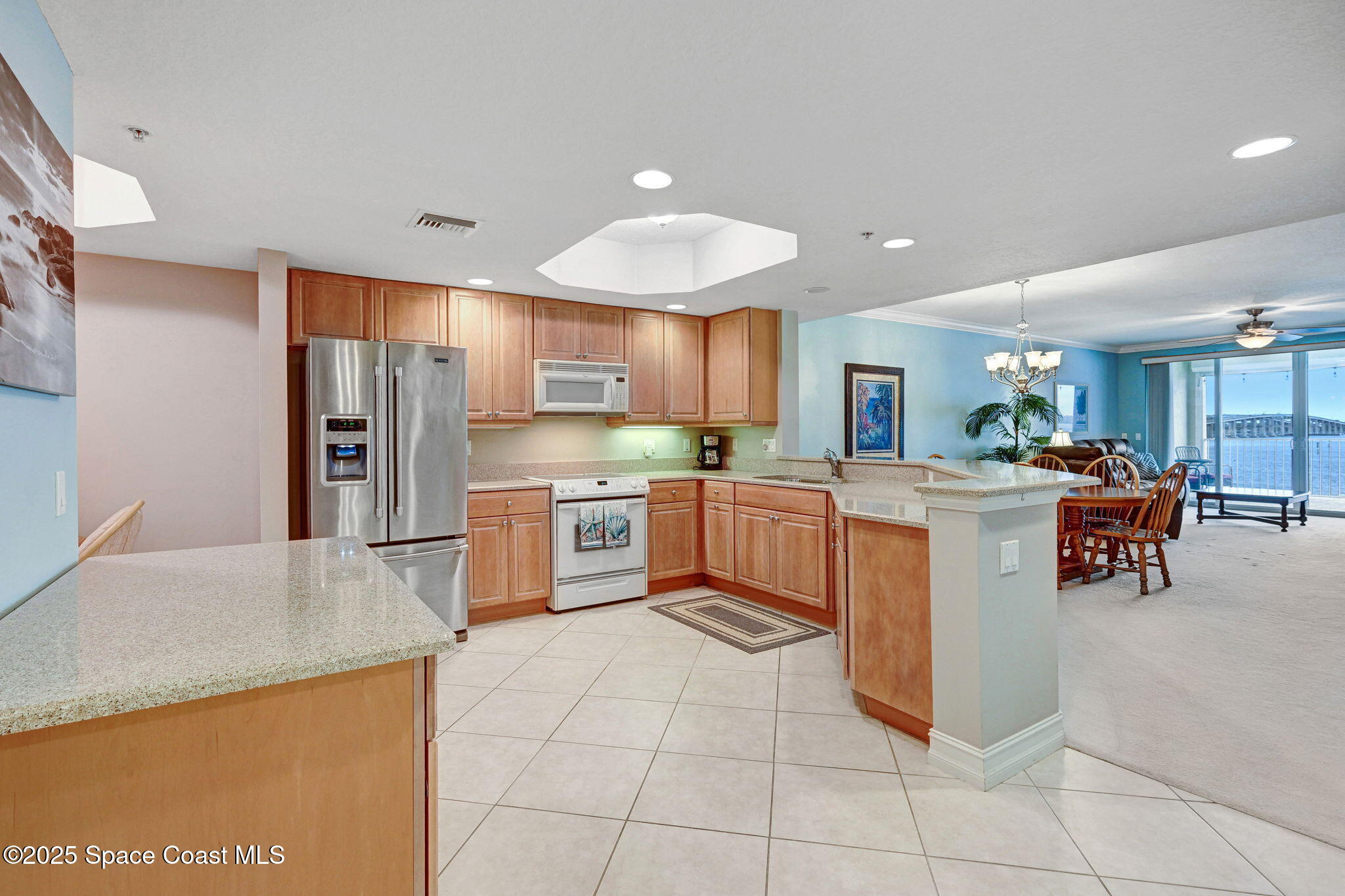 500 Sail Lane, Unit 203 Merritt Island, FL 32953 - Photo 15 of 52 a kitchen with stainless steel appliances a refrigerator a sink dishwasher with a dining table and chairs