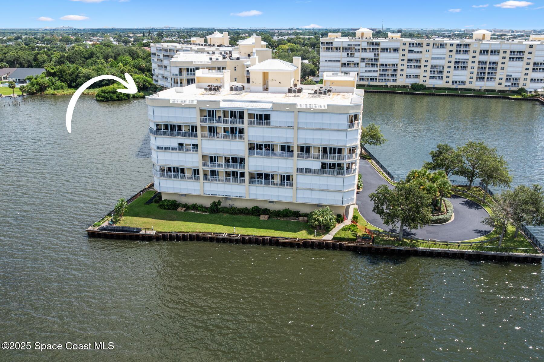 500 Sail Lane, Unit 203 Merritt Island, FL 32953 - Photo 51 of 52 a view of a lake with a building and outdoor seating