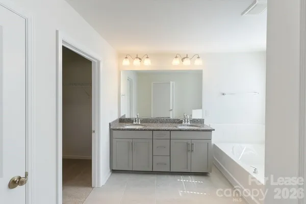 a spacious bathroom with a granite countertop sink and a mirror