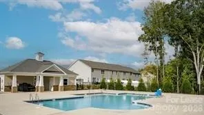 a view of a white house with a large windows and a yard