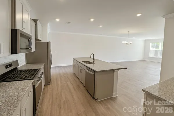a kitchen that has a lot of cabinets and stainless steel appliances