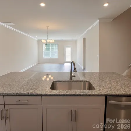 a kitchen with granite countertop a sink and chandelier