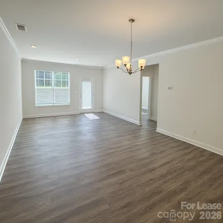 a view of empty room with wooden floor stove and window