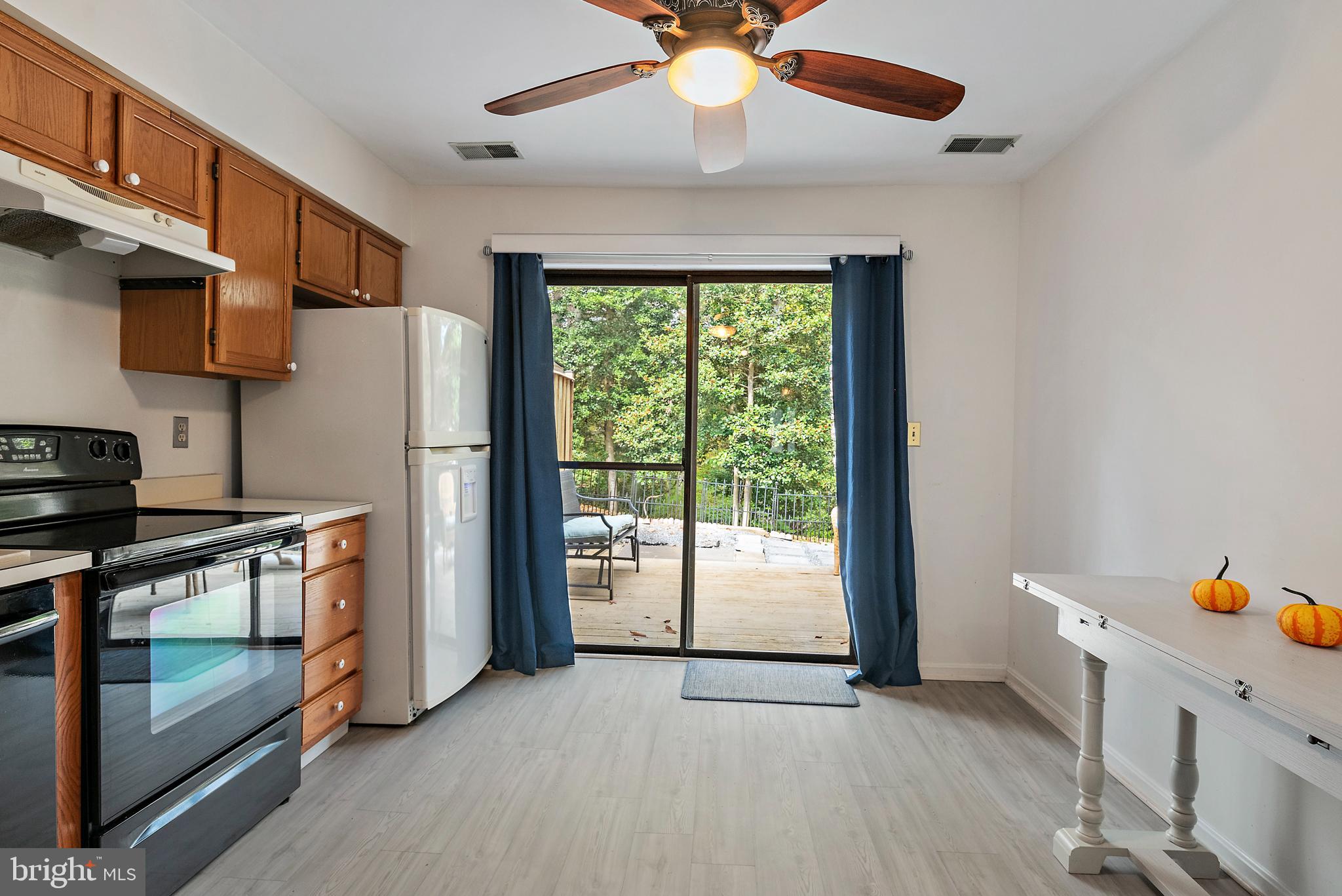 932 Riversedge Circle Annapolis, MD 21401 - Photo 12 of 42 a kitchen with stainless steel appliances a stove a refrigerator with white cabinets and wooden floor
