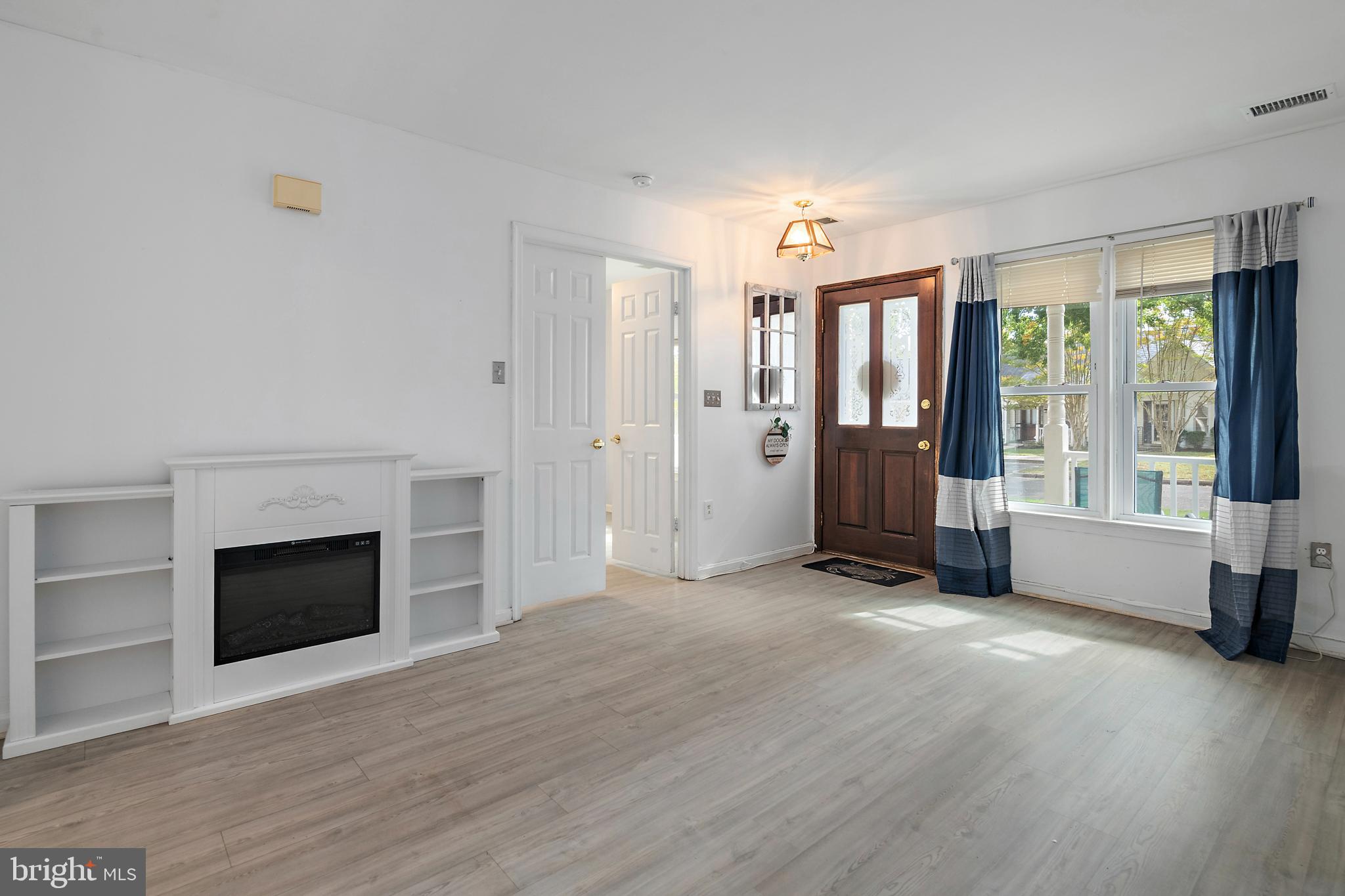 932 Riversedge Circle Annapolis, MD 21401 - Photo 16 of 42 an empty room with wooden floor fireplace and windows